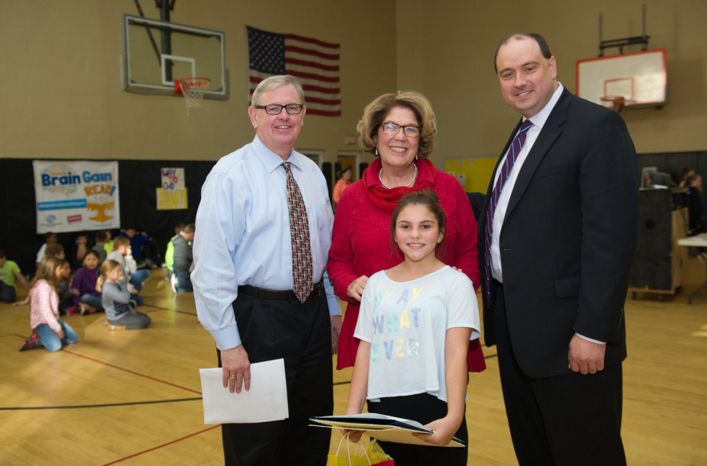 Erin , an 11-year old member of Boys & Girls Clubs of MetroWest, (white shirt) stands with Fran Hurley, President of Boys and Girls Clubs of Metrowest, left, State Rep Kate Hogan, center, and State Senator James Eldridge, right, as she celebrates her accomplishment as a national winner of the “Make Good Reads Happen” contest. To honor Erin, Boys & Girls Clubs of MetroWest hosted a reading celebration event on Monday, Oct. 26, 2015 in Hudson, Mass. Supported by Boys & Girls Clubs of America (BGCA) and Staples, the “Make Good Reads Happen” contest invited Club youth to bring their favorite book to life from BGCA’s Summer Brain Gain: READ! program. (Gretchen Ertl/AP Images Boys & Girls Clubs of America)